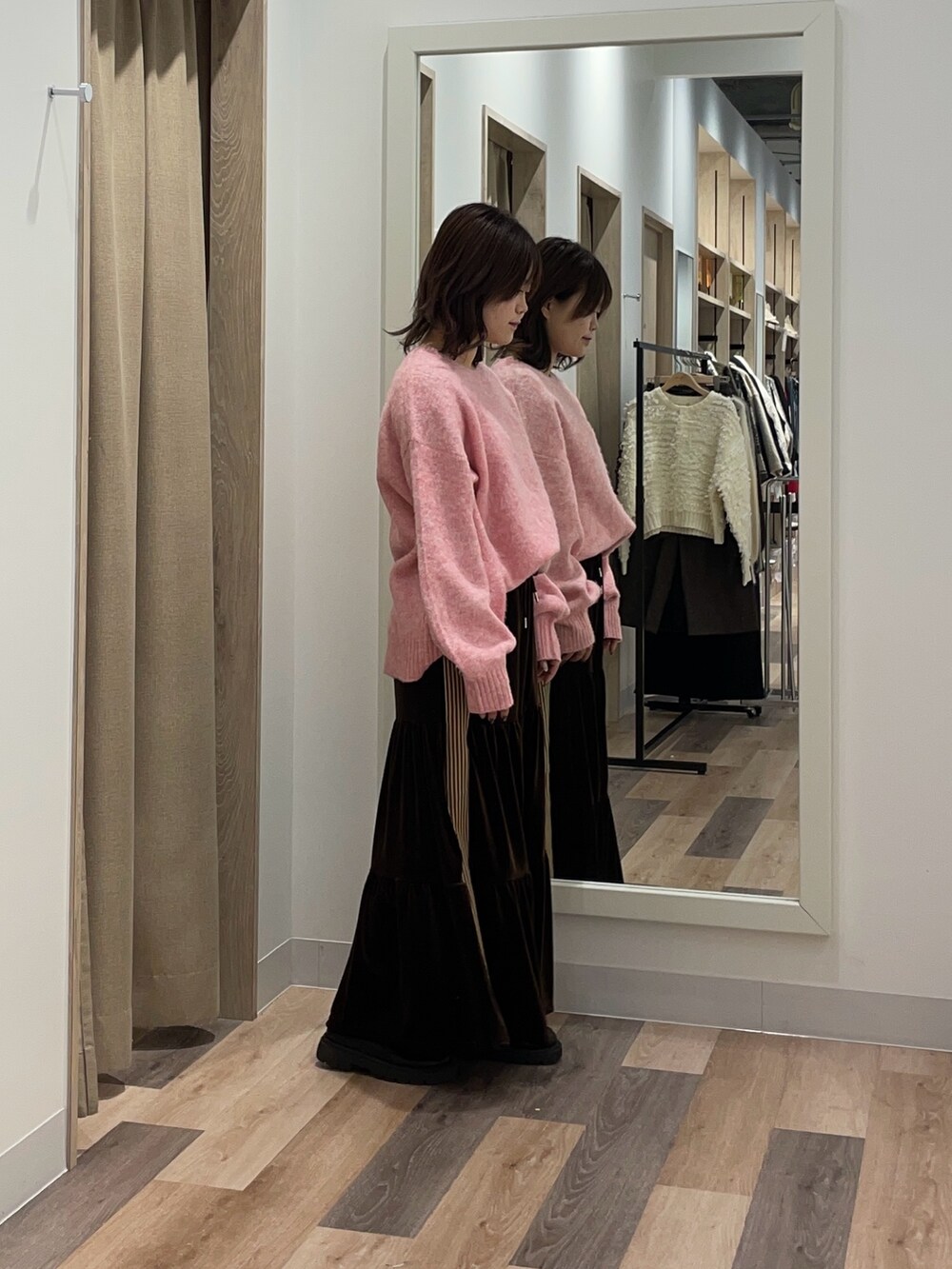 ピンク系のニット/セーター、ブラウン系のスカートを着用したレディースの冬コーディネートの2枚目の写真