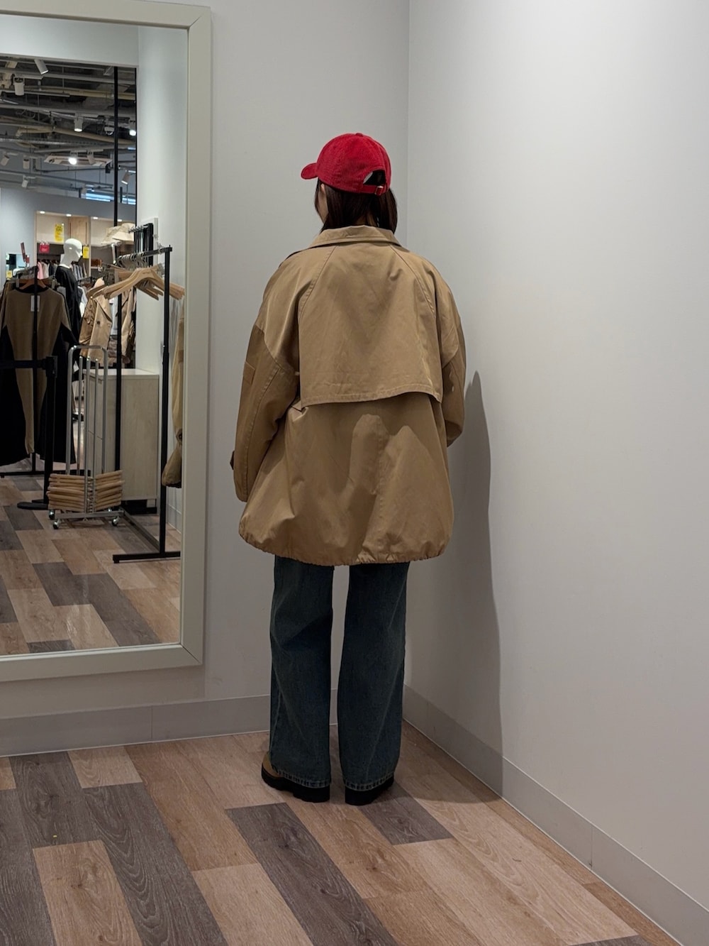 ブルー系のデニムパンツ、ベージュ系のトレンチコート、グレー系のニット/セーターを着用したレディースの冬コーディネートの3枚目の写真