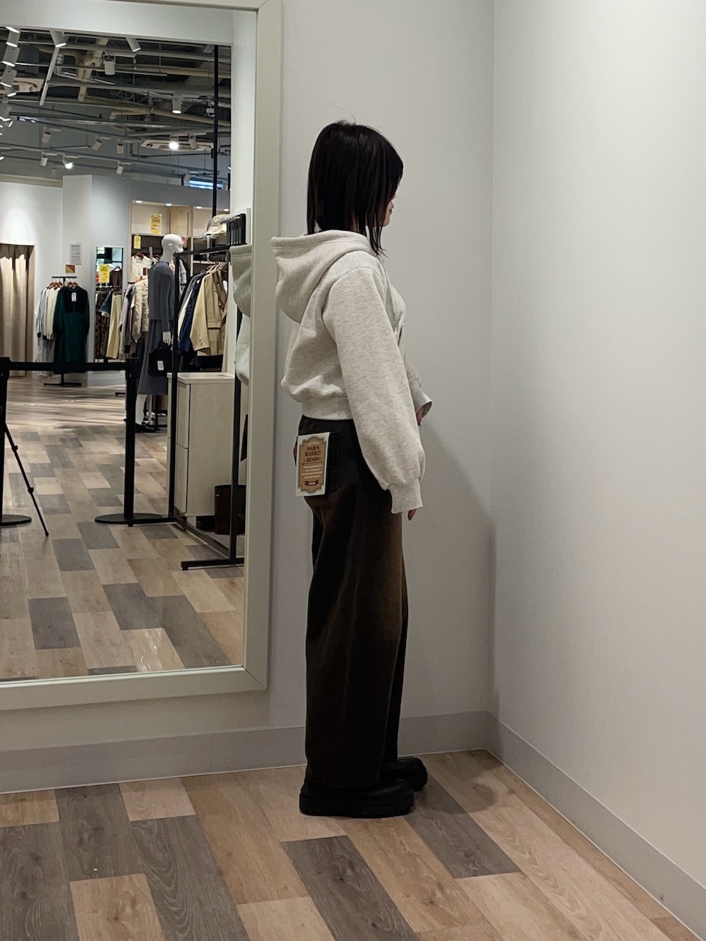 グレー系のパーカー、ブラウン系のデニムパンツを着用したレディースの冬コーディネートの2枚目の写真