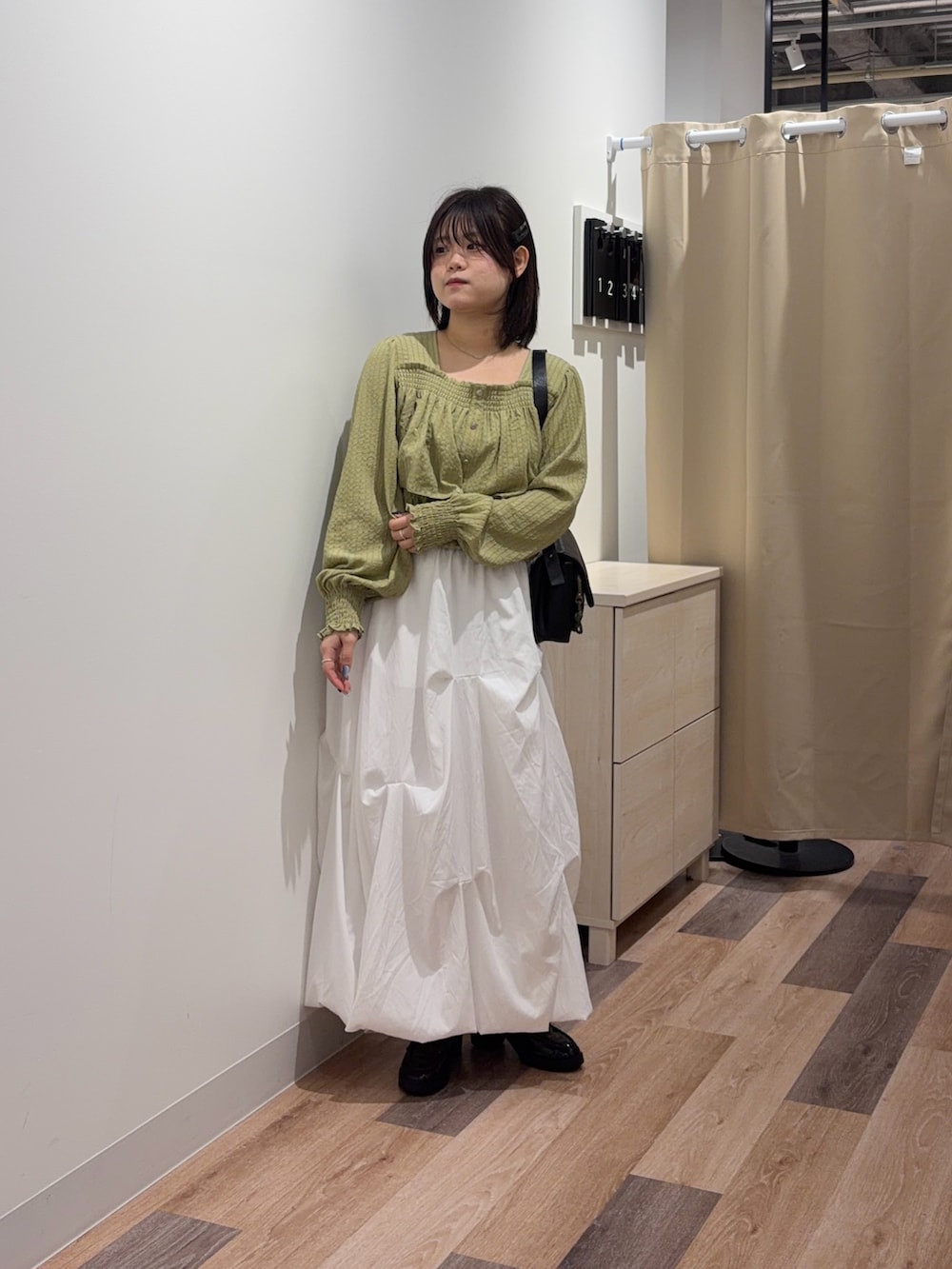 ホワイト系のスカート、ブラック系のトートバッグを着用したレディースの春コーディネートの2枚目の写真