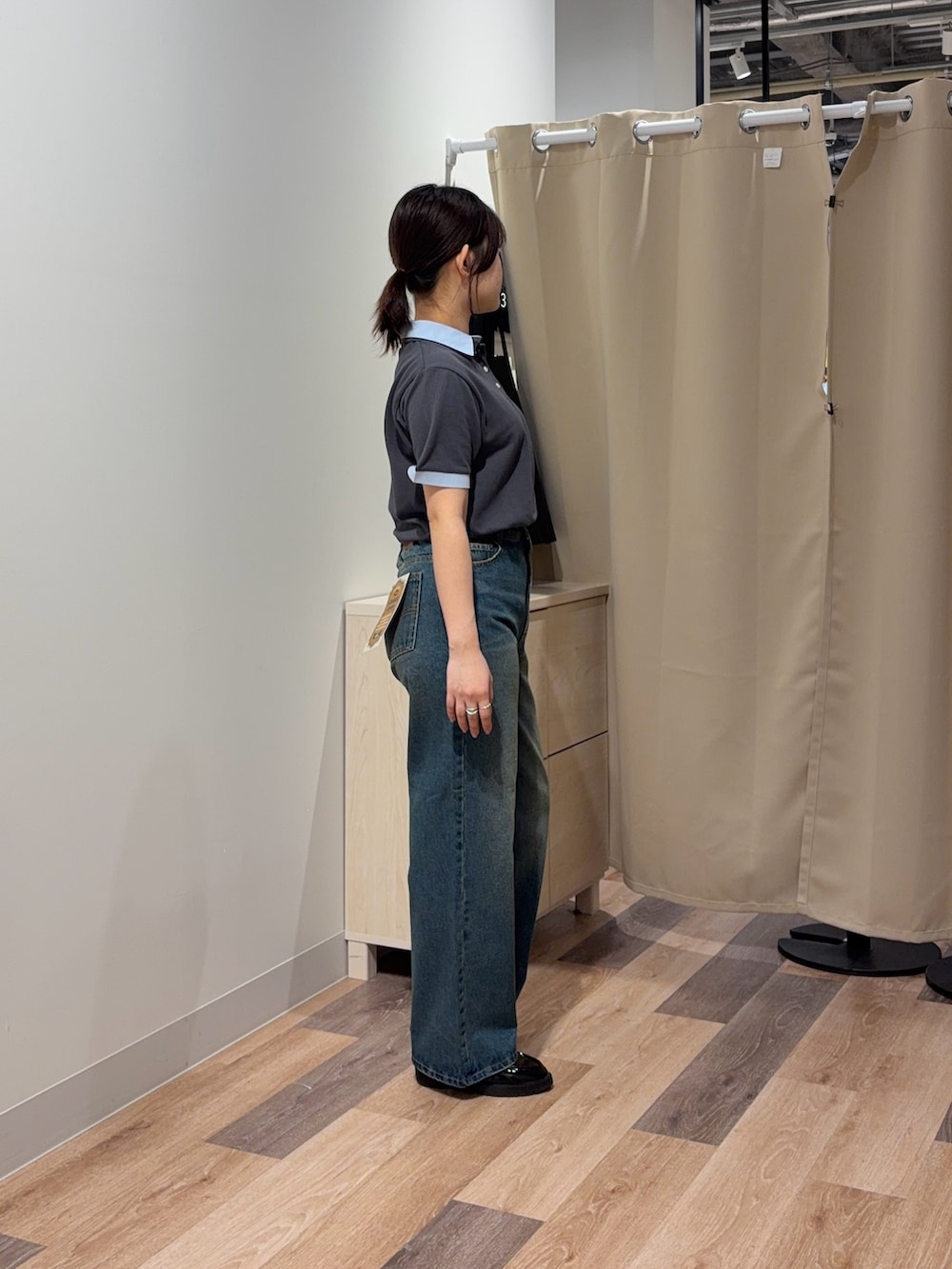 グレー系のポロシャツ、ブルー系のデニムパンツを着用したレディースの春コーディネートの2枚目の写真