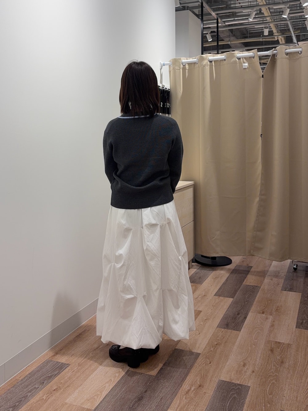 グレー系のカーディガン/ボレロ、ホワイト系のスカート、シルバー系のトートバッグを着用したレディースの春コーディネートの3枚目の写真