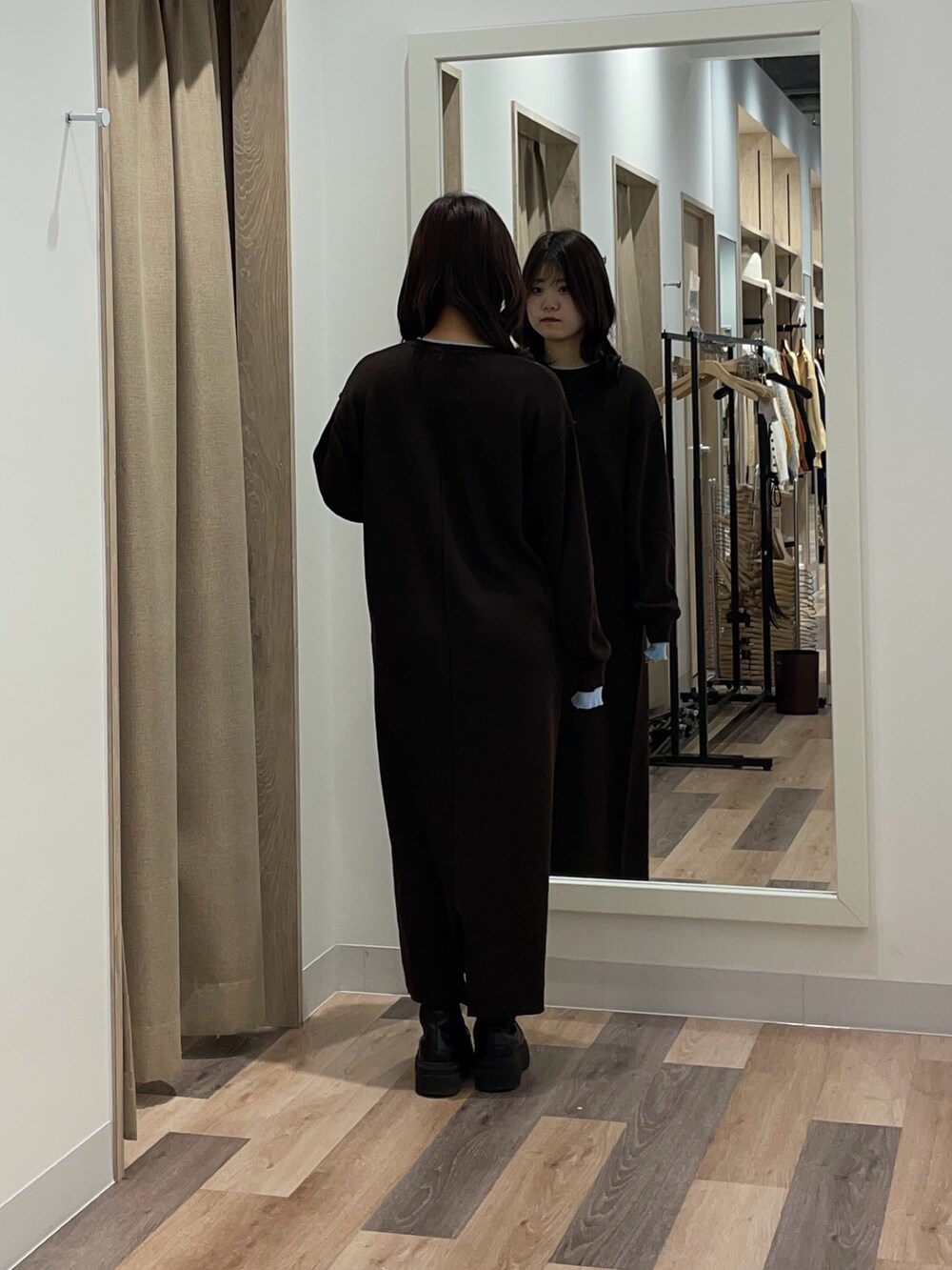 ブラウン系のワンピース、ブラック系のブーツを着用したレディースの秋コーディネートの3枚目の写真