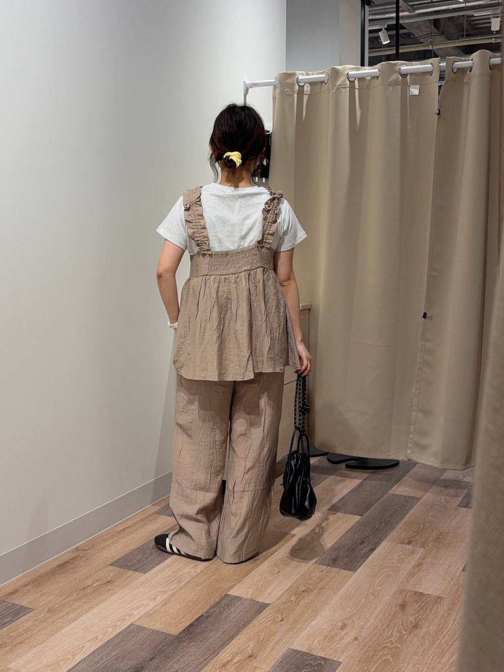 ベージュ系のワンピース、グレー系のTシャツ/カットソー、ブラック系のショルダーバッグを着用したレディースの春コーディネートの3枚目の写真
