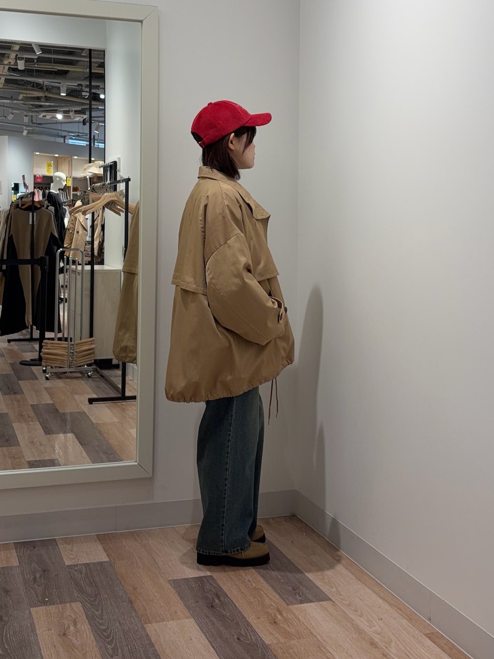 ブルー系のデニムパンツ、ベージュ系のトレンチコート、グレー系のニット/セーターを着用したレディースの冬コーディネートの2枚目の写真