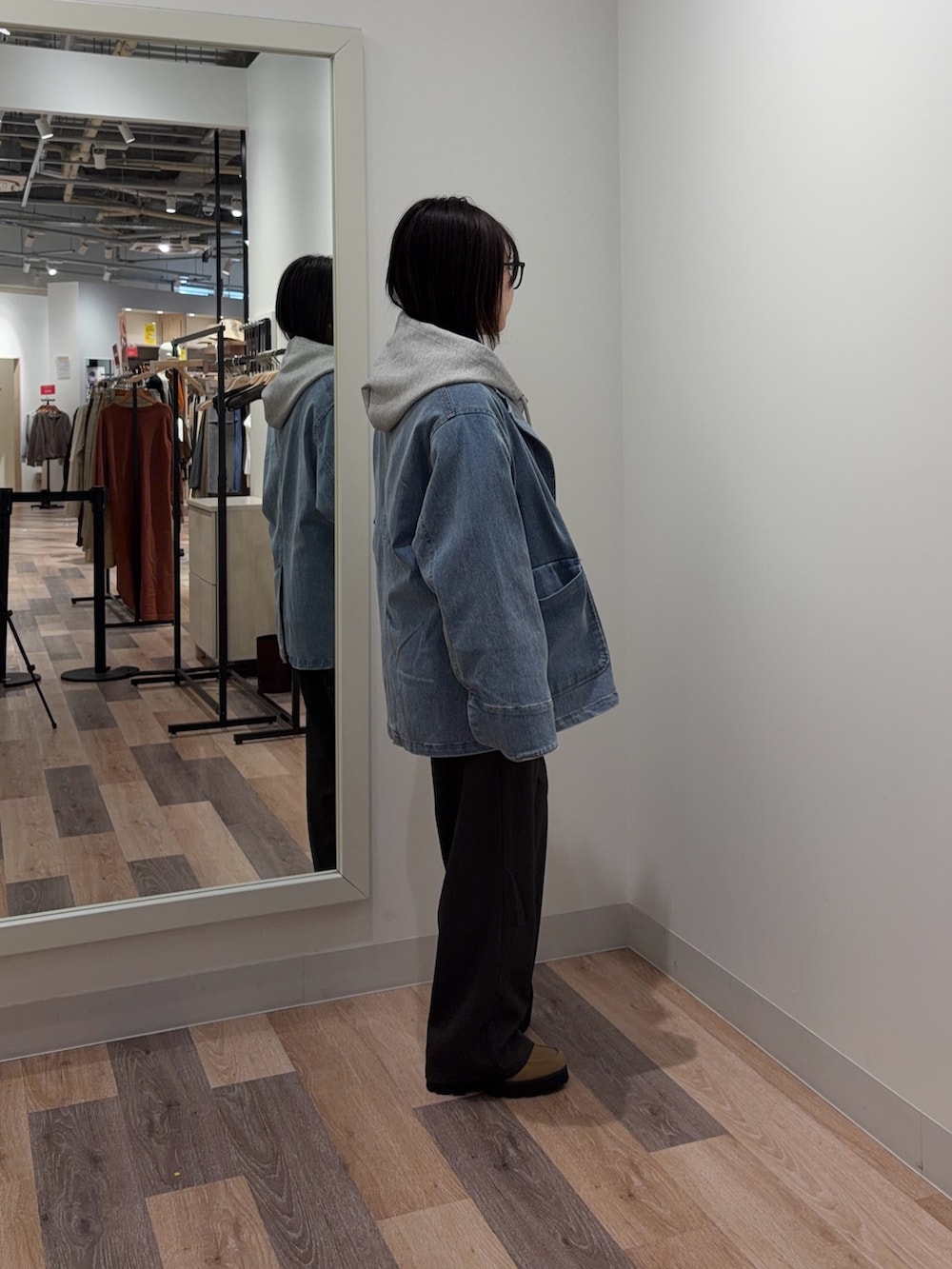 グレー系のパーカー、ブルー系のテーラードジャケット、ブラック系のその他パンツを着用したレディースの春コーディネートの2枚目の写真