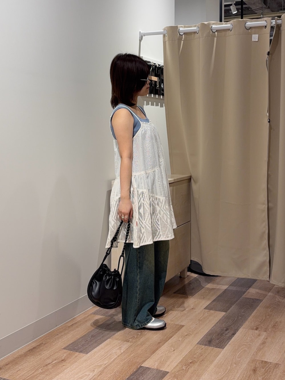 ブルー系のキャミソール、ホワイト系のスカート、ブルー系のデニムパンツを着用したレディースの春コーディネートの2枚目の写真