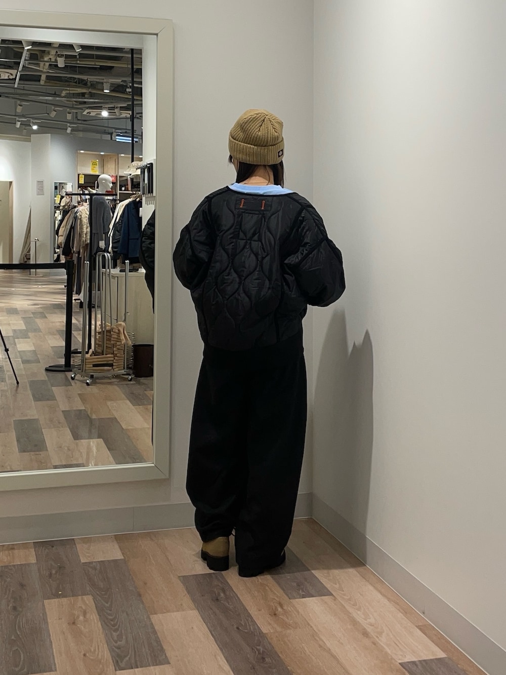 ブラック系のブルゾン、ブルー系のニット/セーター、ブラック系のスラックスを着用したレディースの冬コーディネートの3枚目の写真