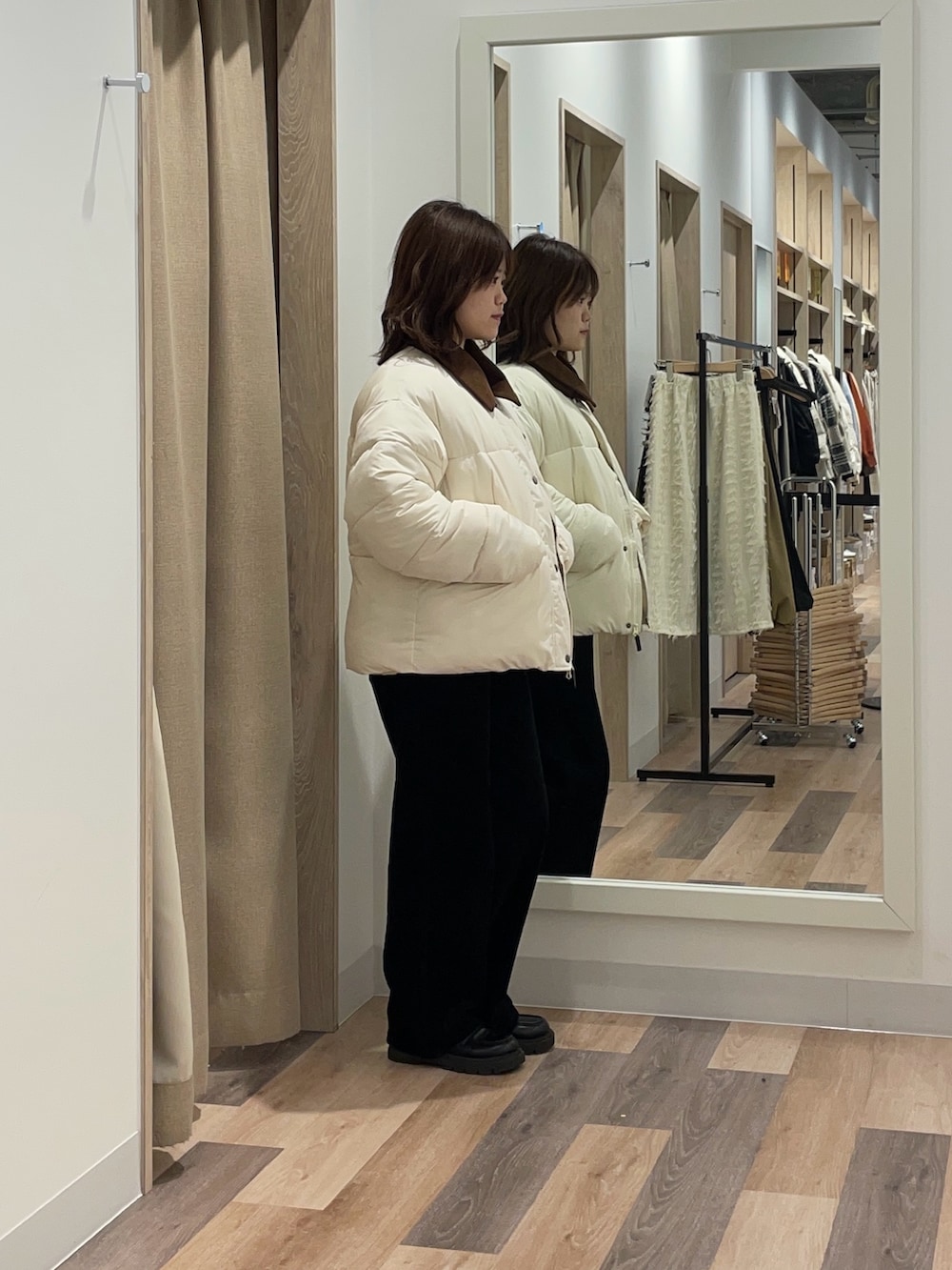 ホワイト系のブルゾン、グリーン系のニット/セーターを着用したレディースの冬コーディネートの3枚目の写真