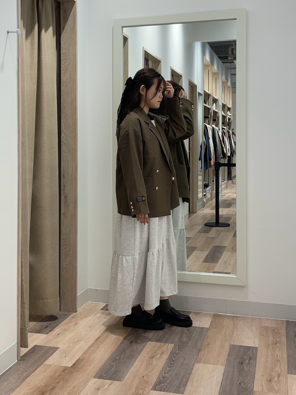 ブラウン系のテーラードジャケット、グレー系のワンピースを着用したレディースの秋コーディネートの2枚目の写真