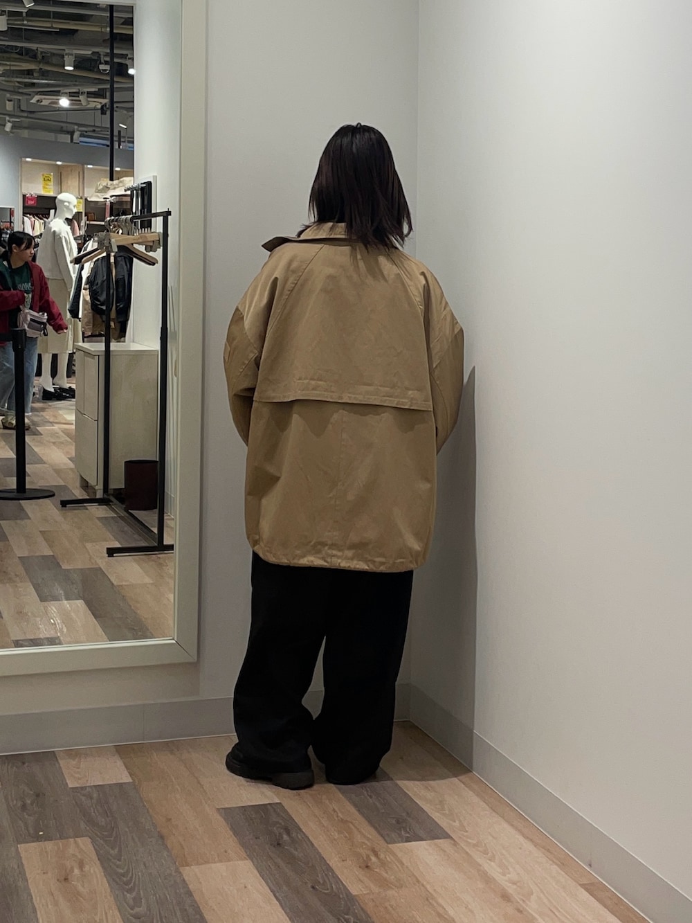 ベージュ系のトレンチコート、ホワイト系のシャツ/ブラウス、グレー系のスラックスを着用したレディースの冬コーディネートの3枚目の写真