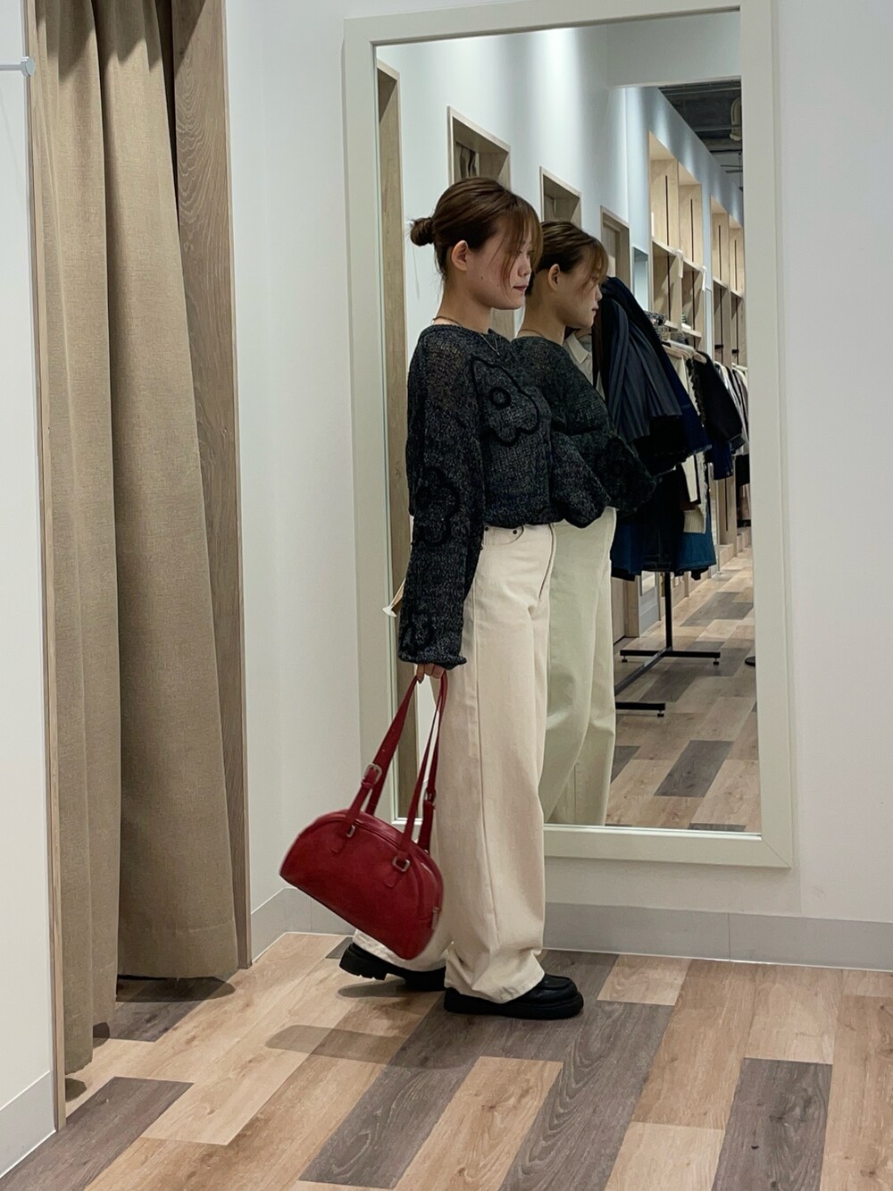 ブラック系のニット/セーター、ブラック系のデニムパンツ、ブラウン系のボストンバッグを着用したレディースの秋コーディネートの2枚目の写真