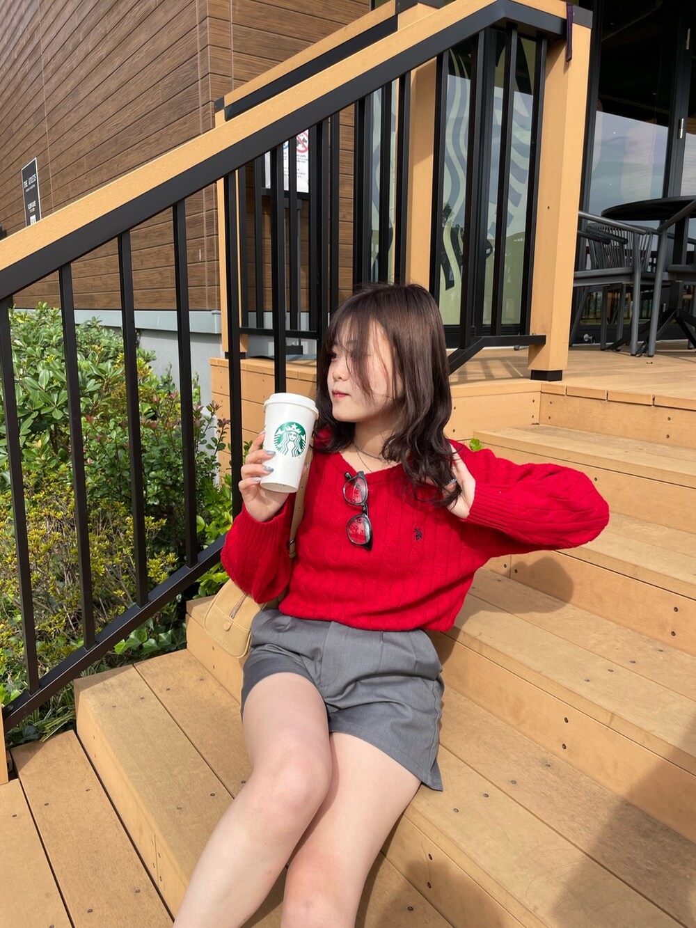 レッド系のニット/セーター、ブラウン系のボストンバッグ、イエロー系のブーツを着用したレディースの秋コーディネートの3枚目の写真