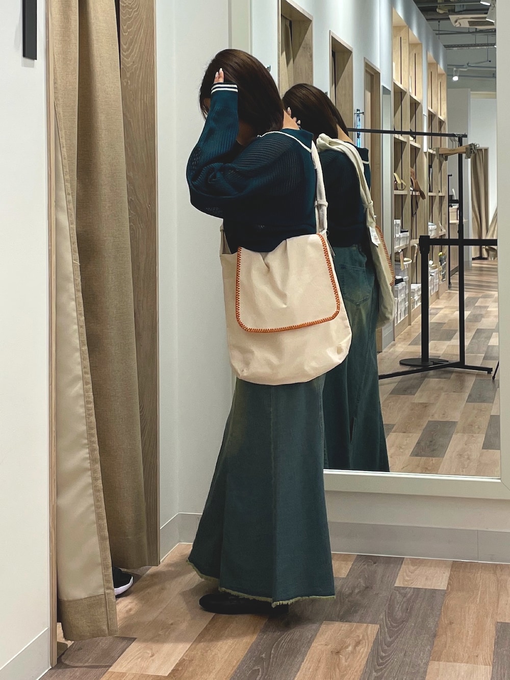 ブルー系のスカート、グリーン系のカーディガン/ボレロ、ホワイト系のショルダーバッグを着用したレディースの夏コーディネートの2枚目の写真