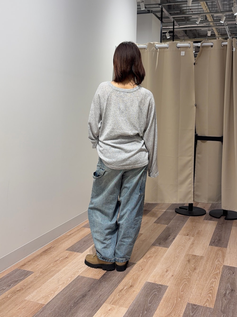 グレー系のニット/セーター、ブルー系のデニムパンツを着用したレディースの春コーディネートの3枚目の写真