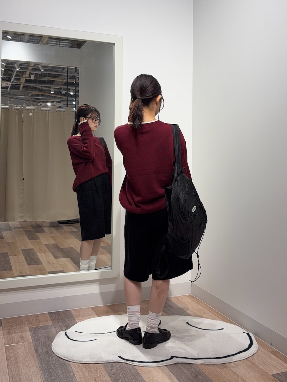 レッド系のニット/セーター、ブラック系のバックパック/リュック、ブラック系のその他シューズを着用したレディースの秋コーディネートの3枚目の写真
