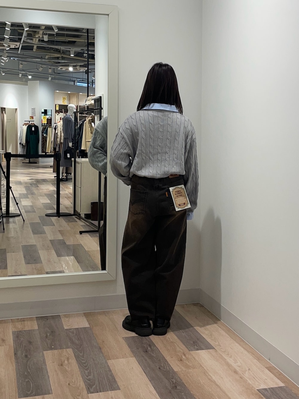 グレー系のニット/セーター、ブラウン系のデニムパンツを着用したレディースの冬コーディネートの3枚目の写真