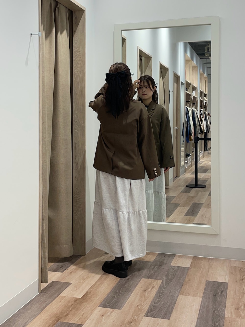 ブラウン系のテーラードジャケット、グレー系のワンピースを着用したレディースの秋コーディネートの3枚目の写真