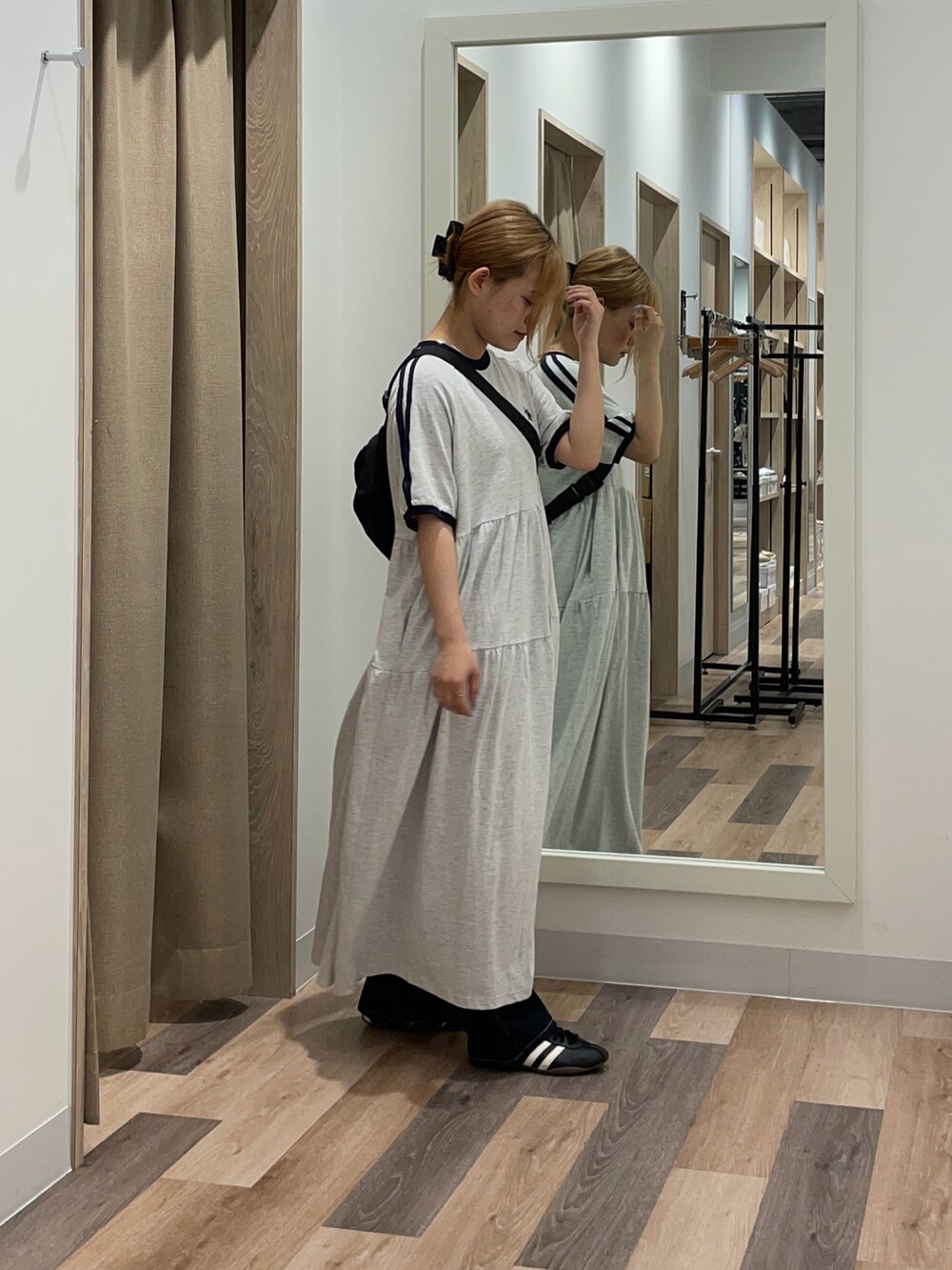 オレンジ系のワンピース、ブラック系のデニムパンツを着用したレディースの夏コーディネートの2枚目の写真