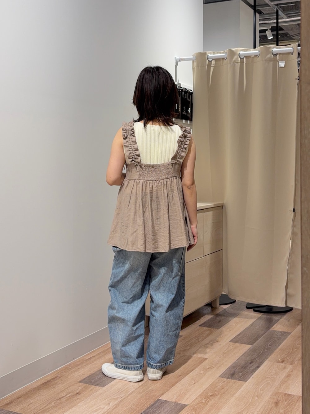 ベージュ系のワンピース、ブルー系のデニムパンツを着用したレディースの夏コーディネートの3枚目の写真
