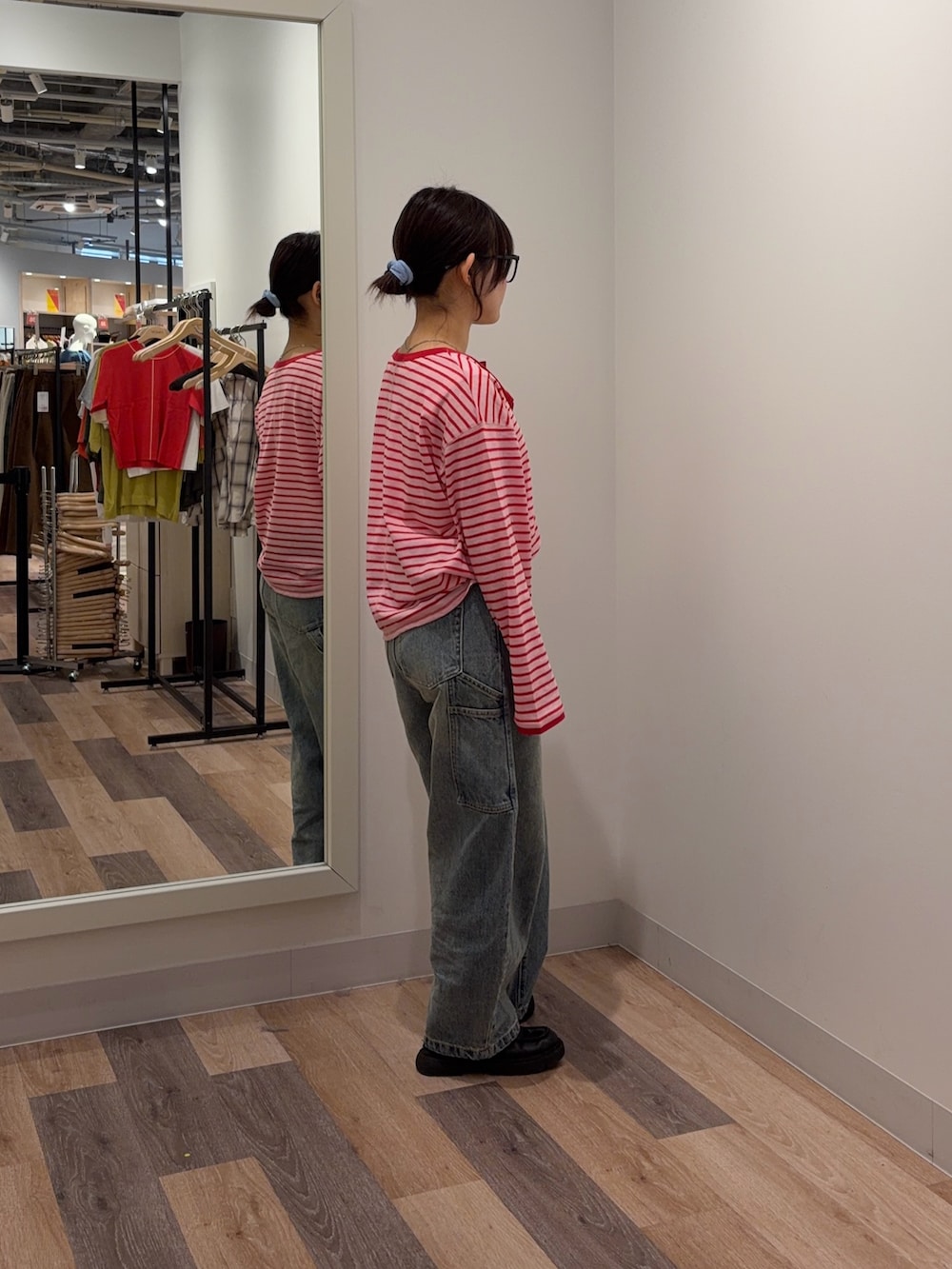 レッド系のTシャツ/カットソー、ブルー系のデニムパンツを着用したレディースの春コーディネートの2枚目の写真