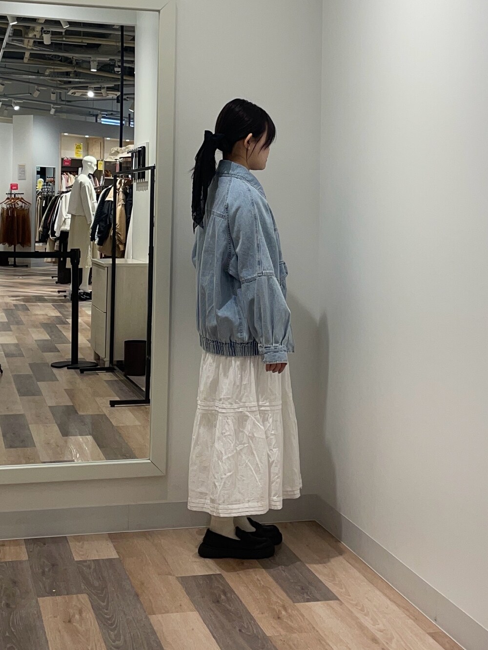 ブルー系のブルゾン、ホワイト系のスカートを着用したレディースの冬コーディネートの2枚目の写真