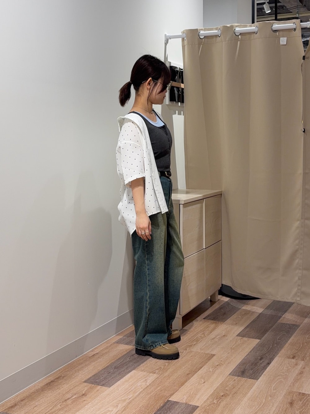 グレー系のキャミソール、ホワイト系のシャツ/ブラウス、ブルー系のデニムパンツを着用したレディースの春コーディネートの2枚目の写真