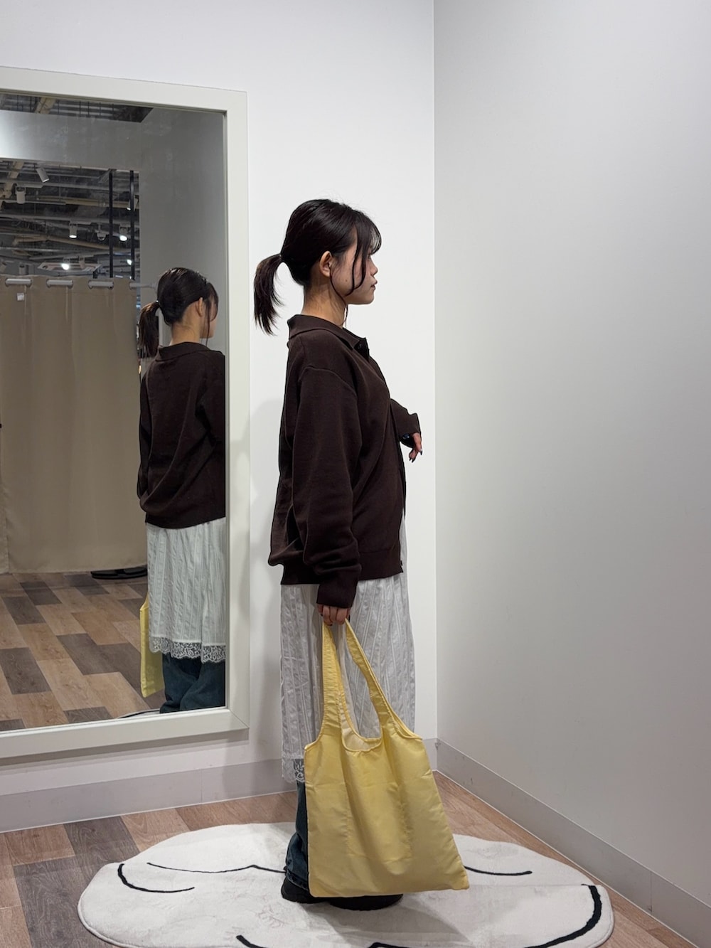 ブラウン系のカーディガン/ボレロ、ホワイト系のスカート、ブルー系のデニムパンツを着用したレディースの秋コーディネートの2枚目の写真