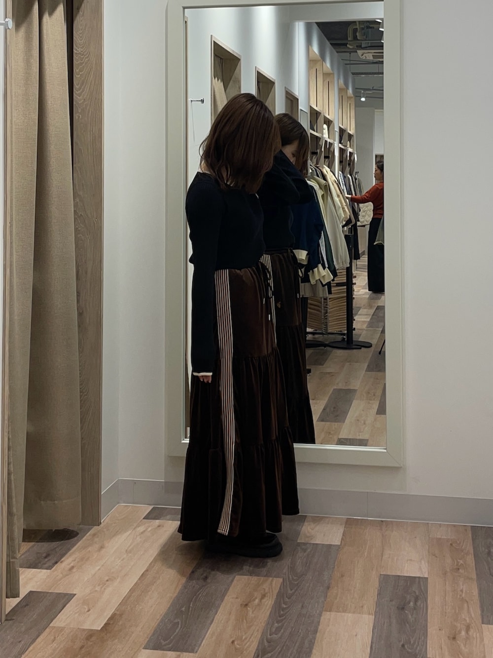 ブラック系のニット/セーター、ブラウン系のスカートを着用したレディースの秋コーディネートの2枚目の写真