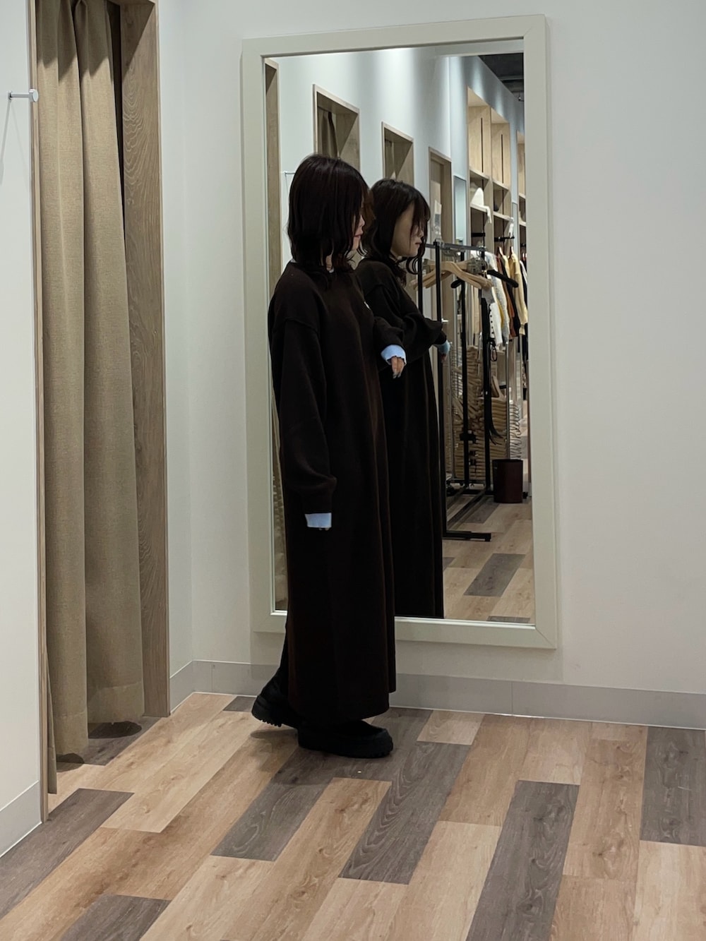 ブラウン系のワンピース、ブラック系のブーツを着用したレディースの秋コーディネートの2枚目の写真