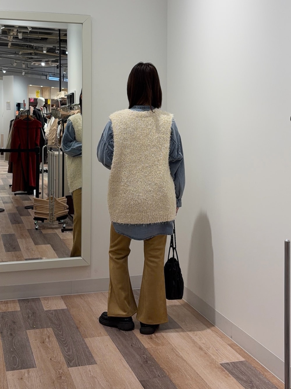 ホワイト系のニット/セーター、ホワイト系のその他パンツ、ブラック系のショルダーバッグを着用したレディースの冬コーディネートの3枚目の写真