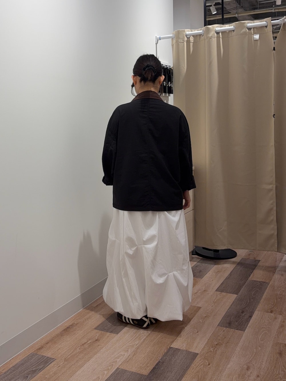 ブラック系のブルゾン、ホワイト系のスカートを着用したレディースの春コーディネートの3枚目の写真