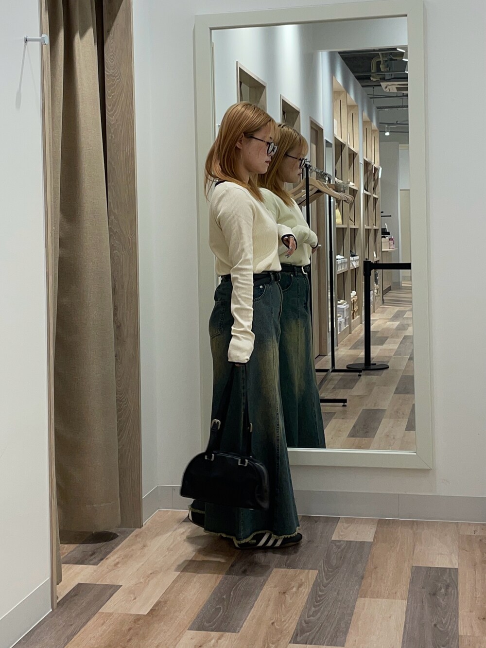 ブラウン系のボストンバッグ、ブルー系のスカート、ホワイト系のTシャツ/カットソーを着用したレディースの夏コーディネートの2枚目の写真