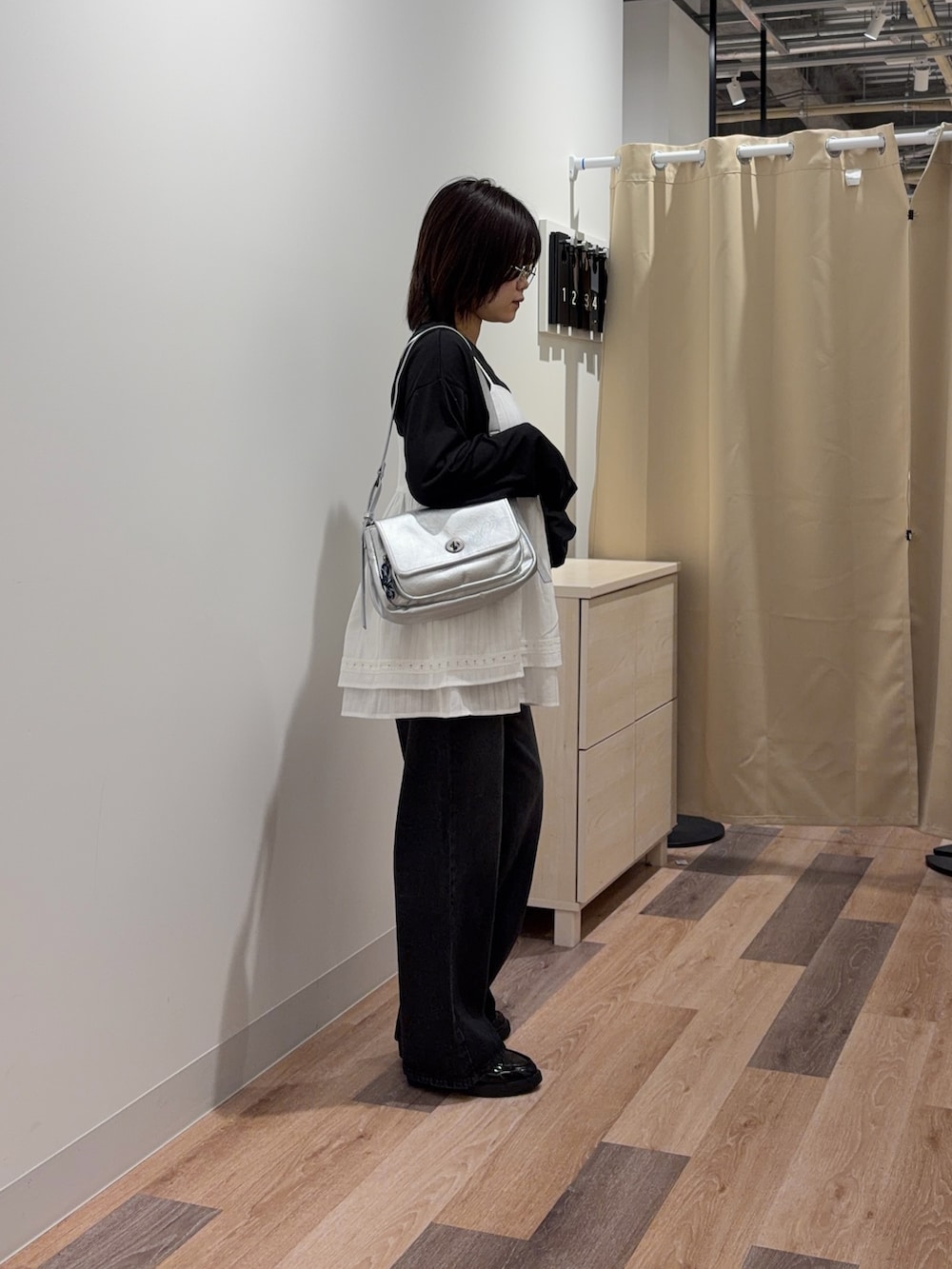 ブラック系のTシャツ/カットソー、ホワイト系のワンピース、ブラック系のデニムパンツを着用したレディースの春コーディネートの2枚目の写真