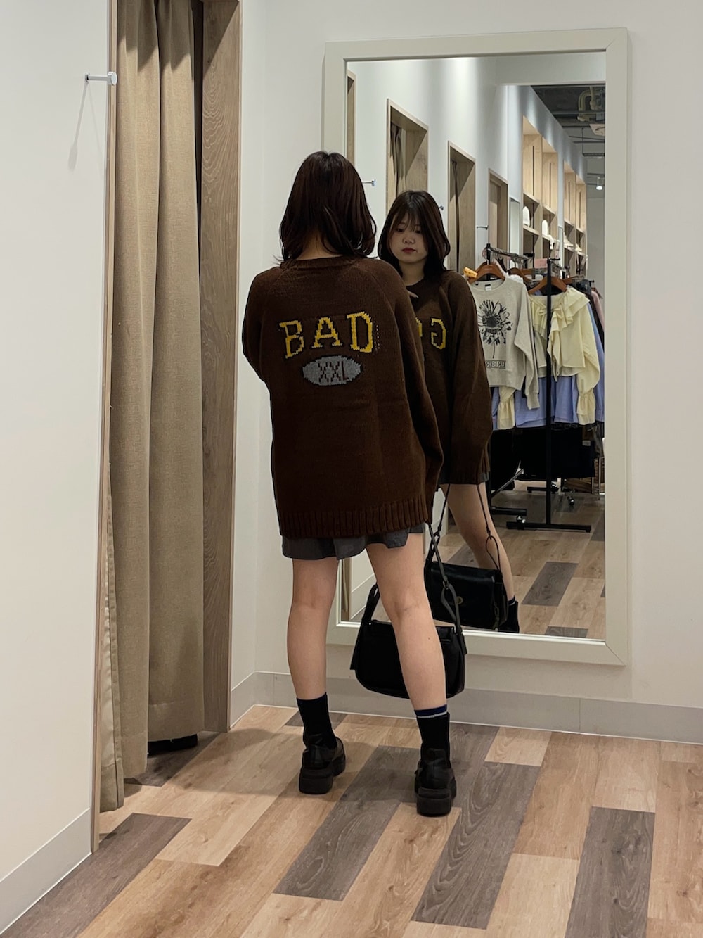 ブラック系のブーツ、ブラウン系のニット/セーター、ブラック系のトートバッグを着用したレディースの秋コーディネートの3枚目の写真