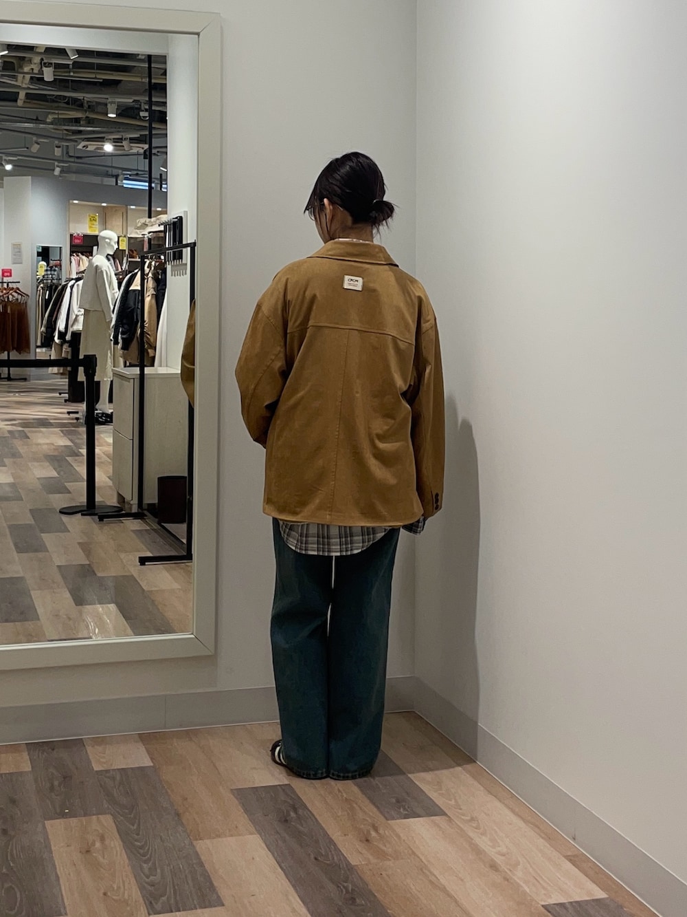 イエロー系のブルゾン、ホワイト系のシャツ/ブラウス、ブルー系のデニムパンツを着用したレディースの冬コーディネートの3枚目の写真