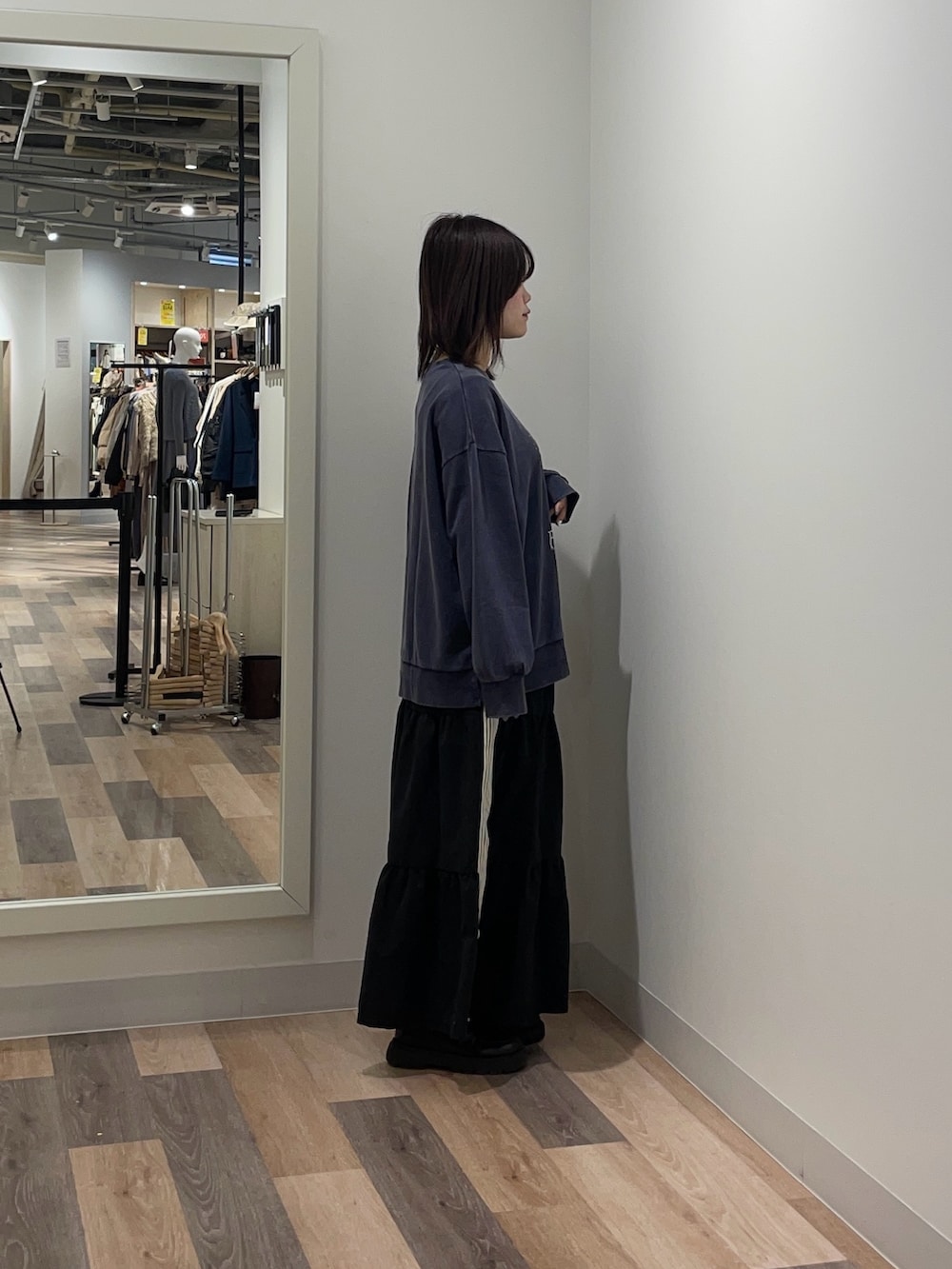 ブルー系のニット/セーター、ブラック系のスカートを着用したレディースの冬コーディネートの2枚目の写真