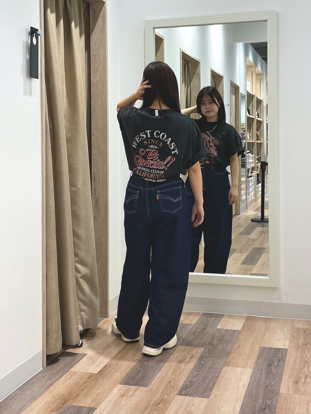 ブルー系のデニムパンツ、ブラック系のTシャツ/カットソー、ブラック系のスニーカーを着用したレディースの夏コーディネートの3枚目の写真