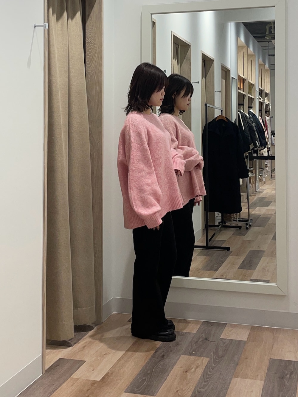 ピンク系のニット/セーター、ブラック系のその他パンツを着用したレディースの冬コーディネートの2枚目の写真