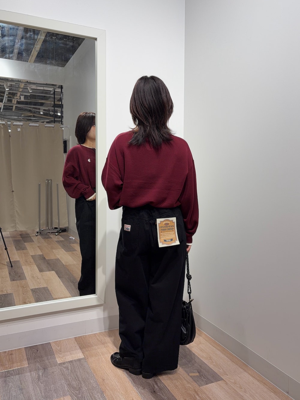 レッド系のニット/セーター、ブラック系のその他パンツ、ブラック系のショルダーバッグを着用したレディースの秋コーディネートの3枚目の写真