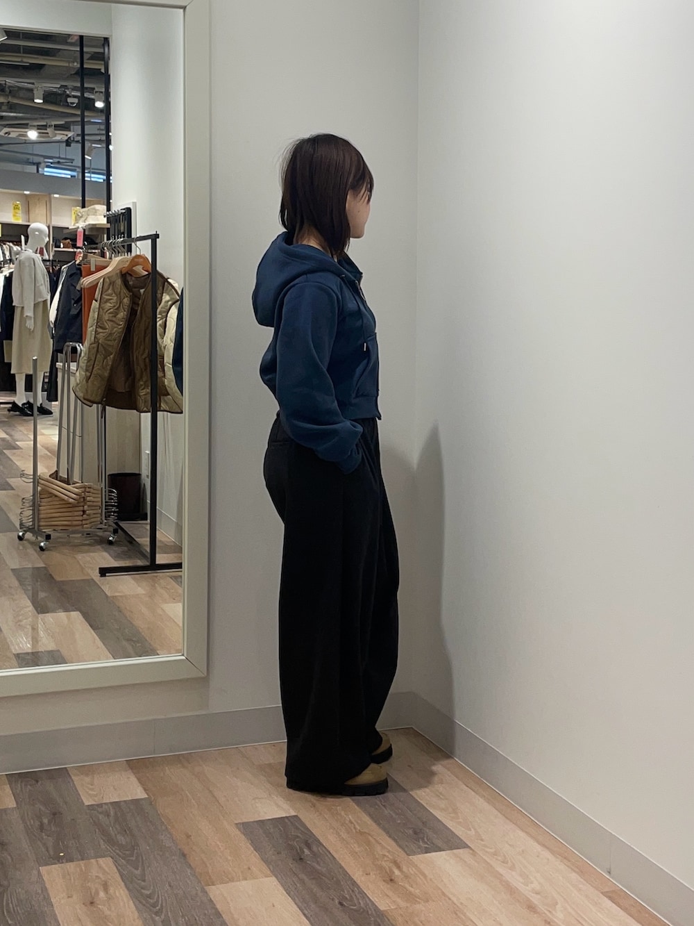 ブルー系のパーカー、ブラック系のスラックスを着用したレディースの冬コーディネートの2枚目の写真