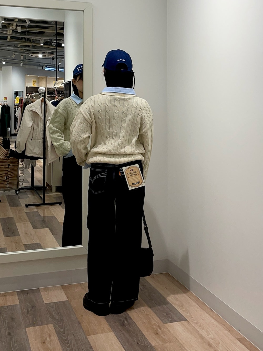 ホワイト系のニット/セーター、ブルー系のデニムパンツ、ブラック系のトートバッグを着用したレディースの冬コーディネートの3枚目の写真