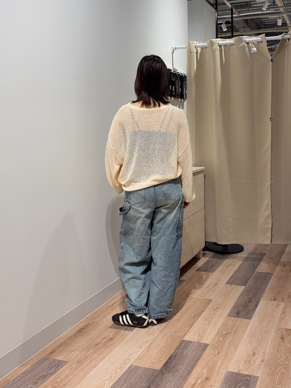 ブルー系のキャミソール、ブルー系のデニムパンツ、ホワイト系のニット/セーターを着用したレディースの春コーディネートの3枚目の写真