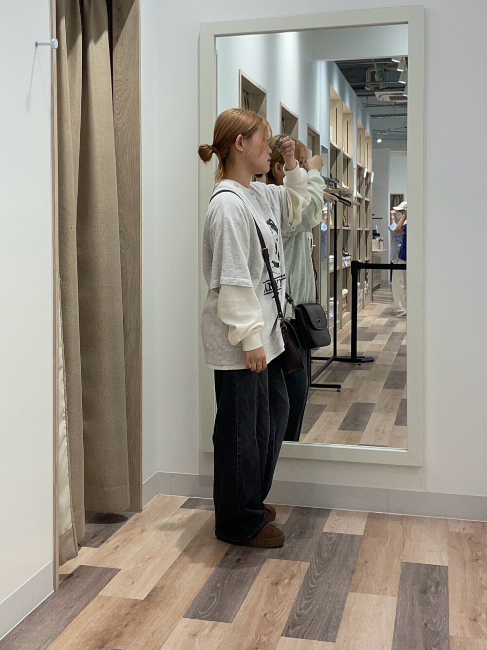 グレー系のTシャツ/カットソー、ブラック系のデニムパンツ、ブラック系のショルダーバッグを着用したレディースの夏コーディネートの2枚目の写真