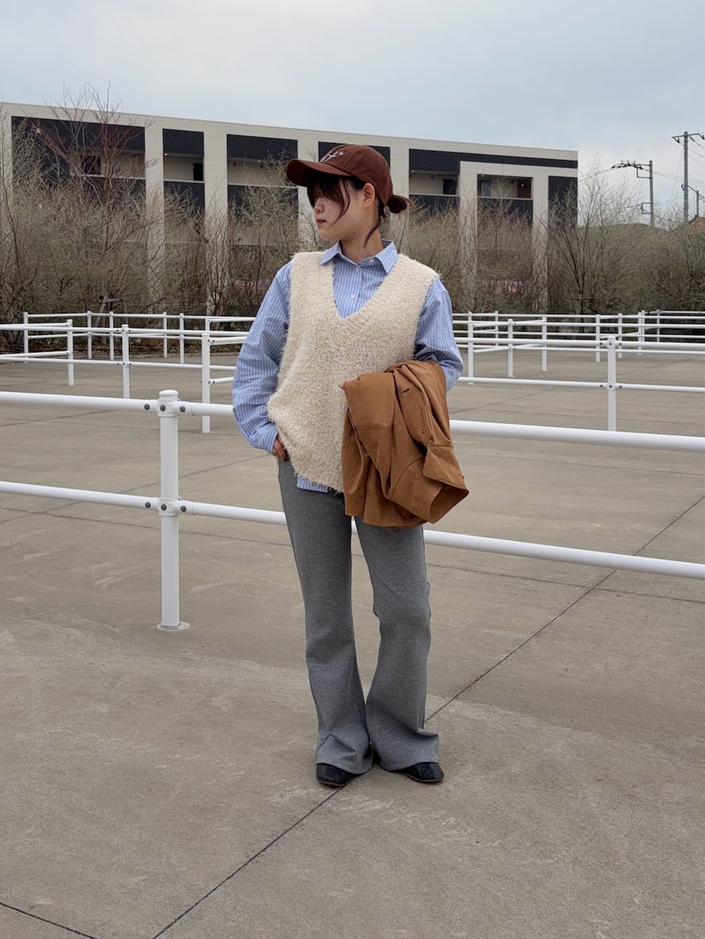 イエロー系のブルゾン、ホワイト系のニット/セーター、ブルー系のシャツ/ブラウスを着用したレディースの春コーディネートの2枚目の写真