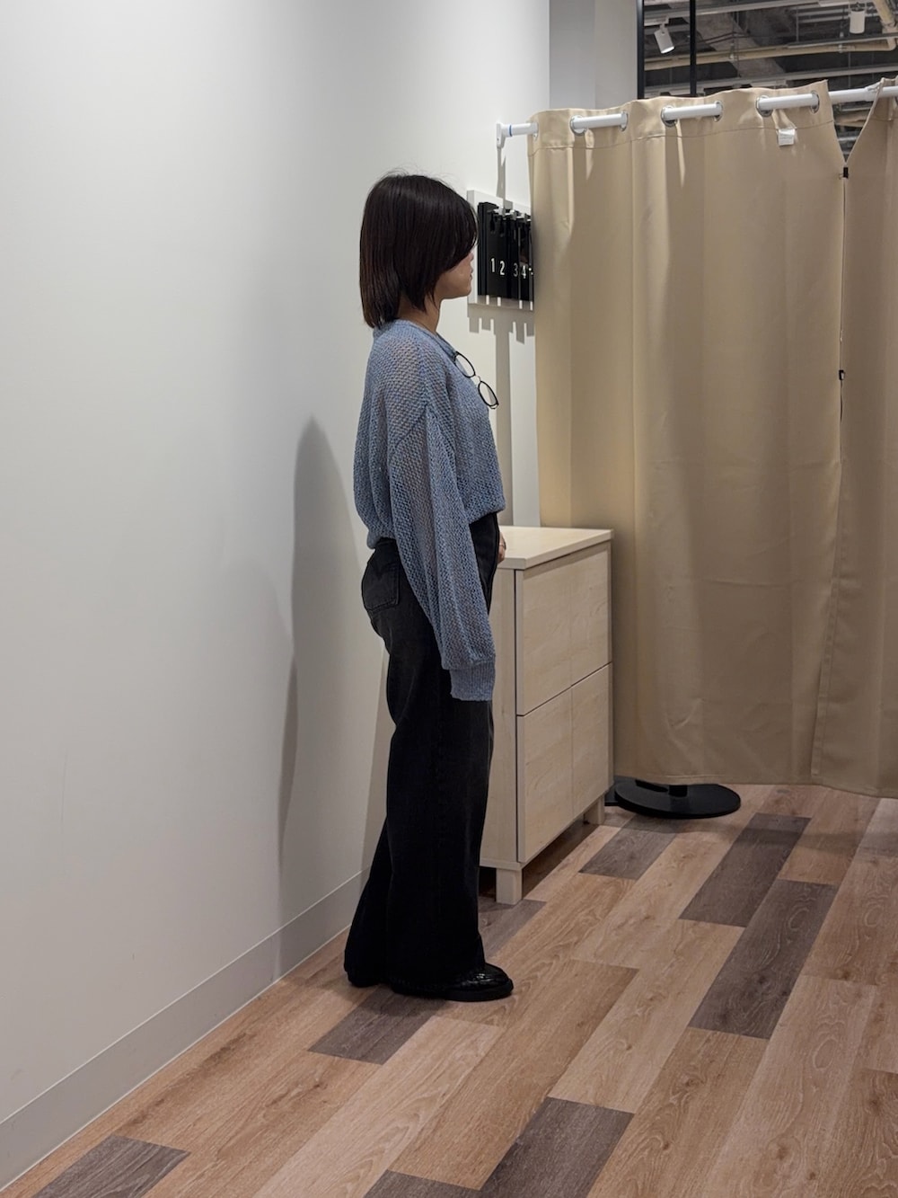 ブルー系のニット/セーター、ブラック系のデニムパンツを着用したレディースの春コーディネートの2枚目の写真