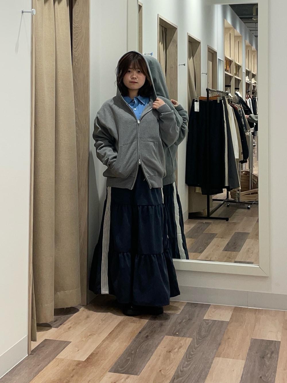 ブラック系のブルゾン、グレー系のニット/セーター、ブルー系のスカートを着用したレディースの冬コーディネートの2枚目の写真