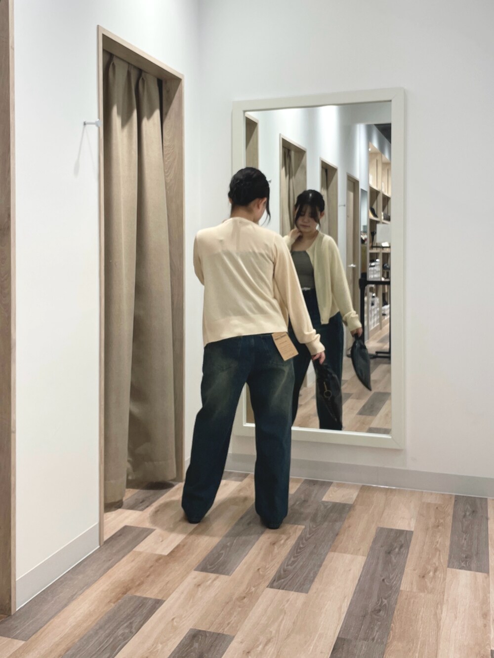 グレー系のカーディガン/ボレロ、ブルー系のデニムパンツ、ブラック系のショルダーバッグを着用したレディースの春コーディネートの3枚目の写真