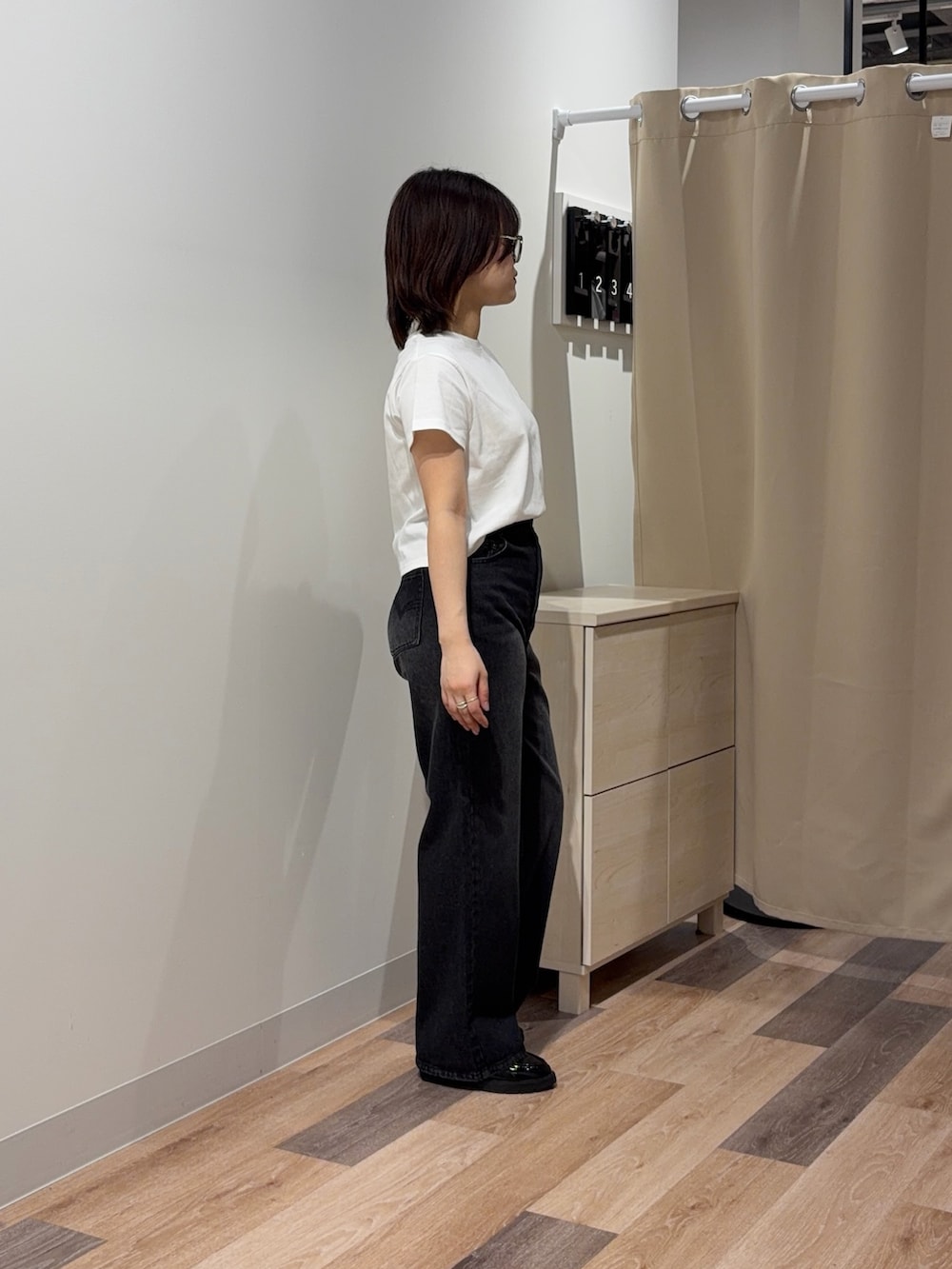 ホワイト系のTシャツ/カットソー、ブラック系のデニムパンツを着用したレディースの春コーディネートの2枚目の写真