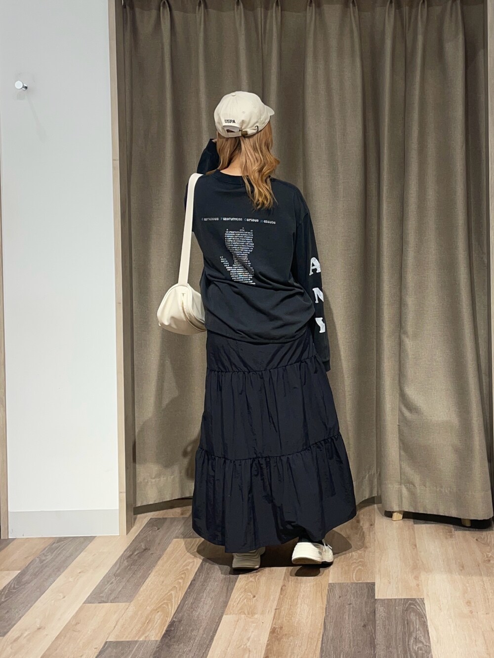 ホワイト系のスカート、ブラック系のTシャツ/カットソーを着用したレディースの夏コーディネートの3枚目の写真